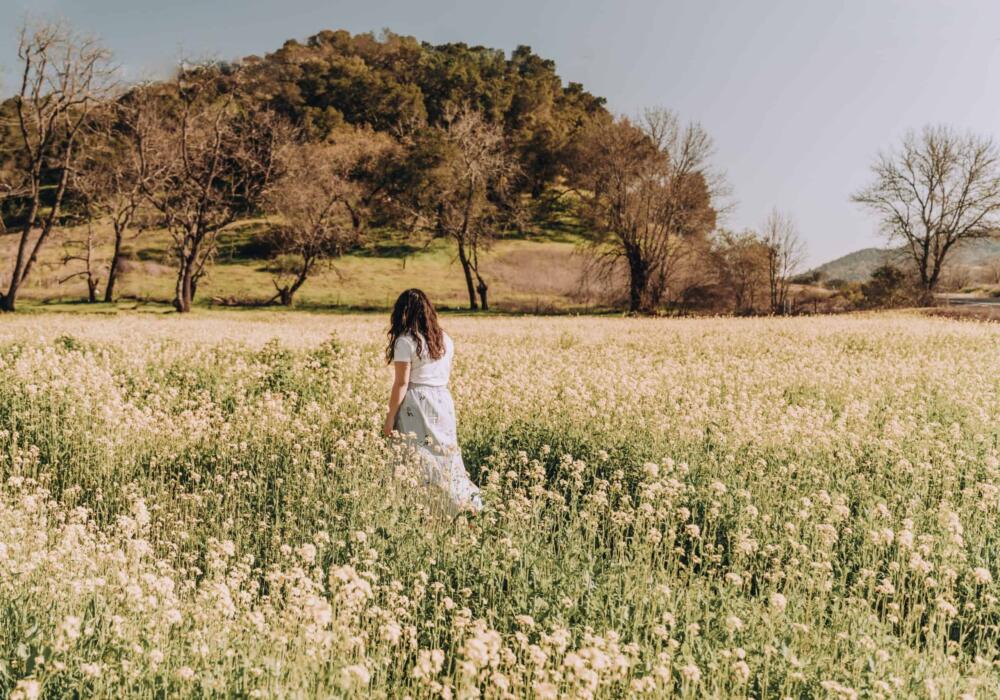 Wanderlust-woman-in-flower-field-feeling-peaceful-26ejwwt-scaled