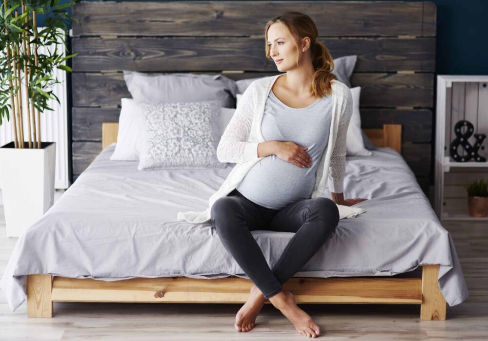 Portrait-pregnant-woman-resting-bedroom-scaled