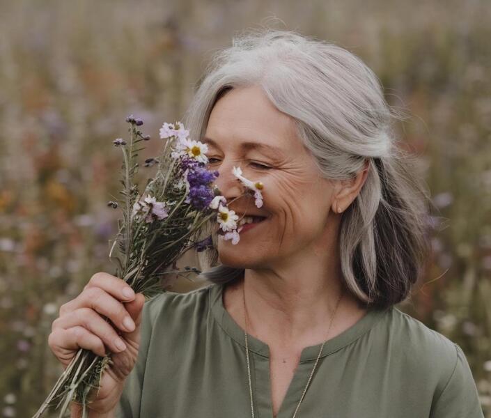 Mature woman smelling flowers