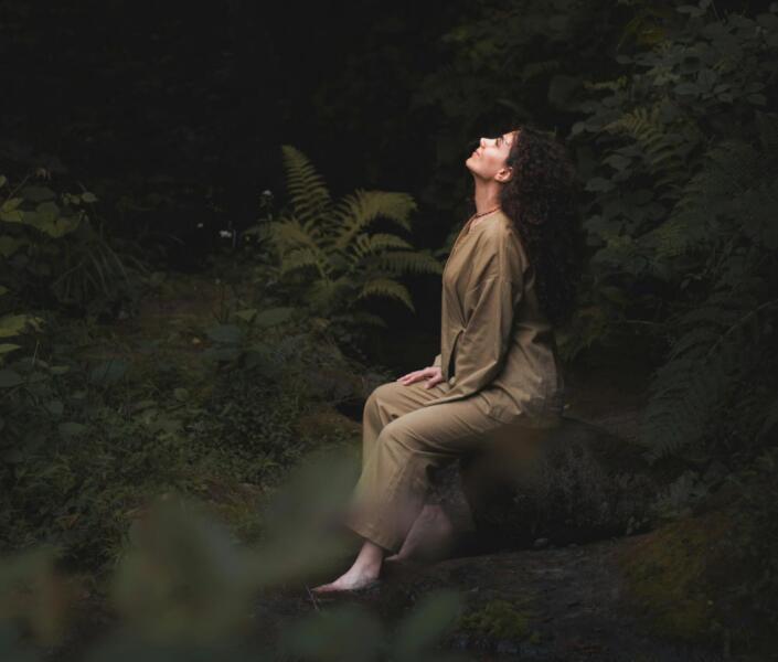 Woman sitting in forest considering counselling & support services