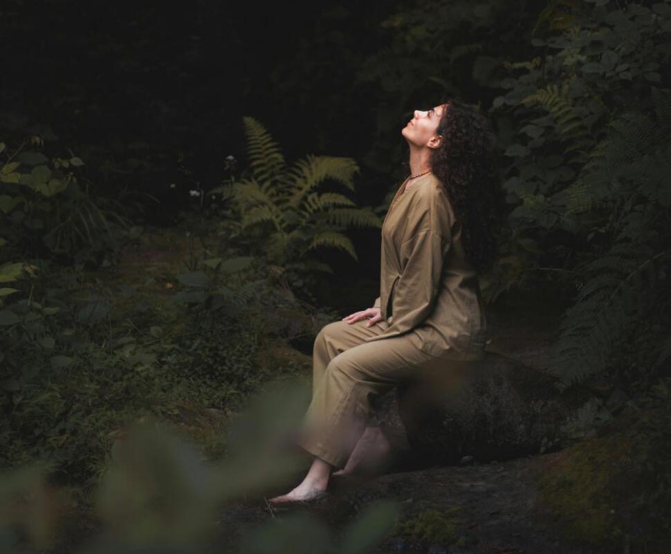 Woman sitting in forest considering counselling & support services